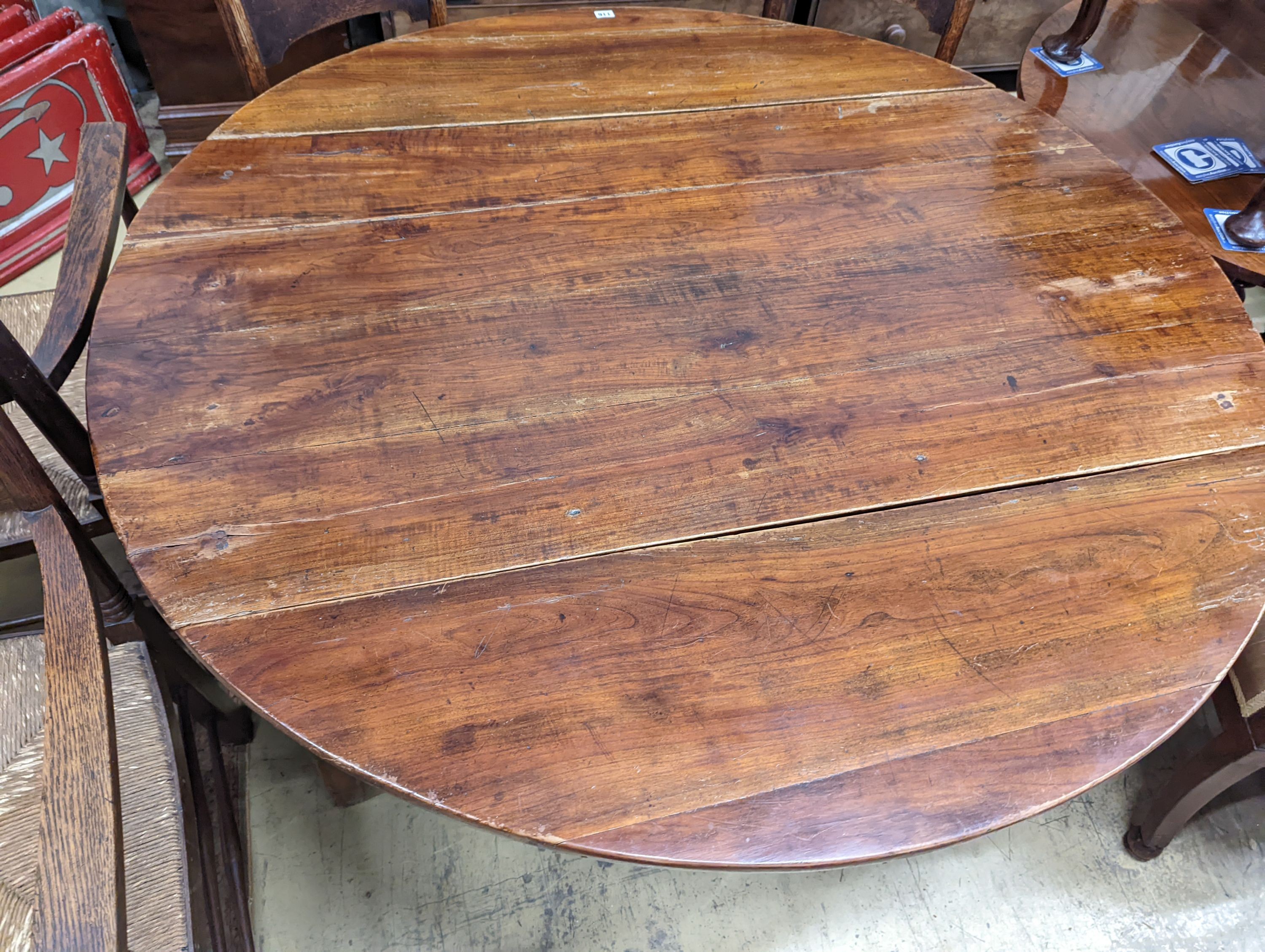A 19th century French fruitwood circular dropleaf dining table, length 145cm extended, width 144cm, height 73cm